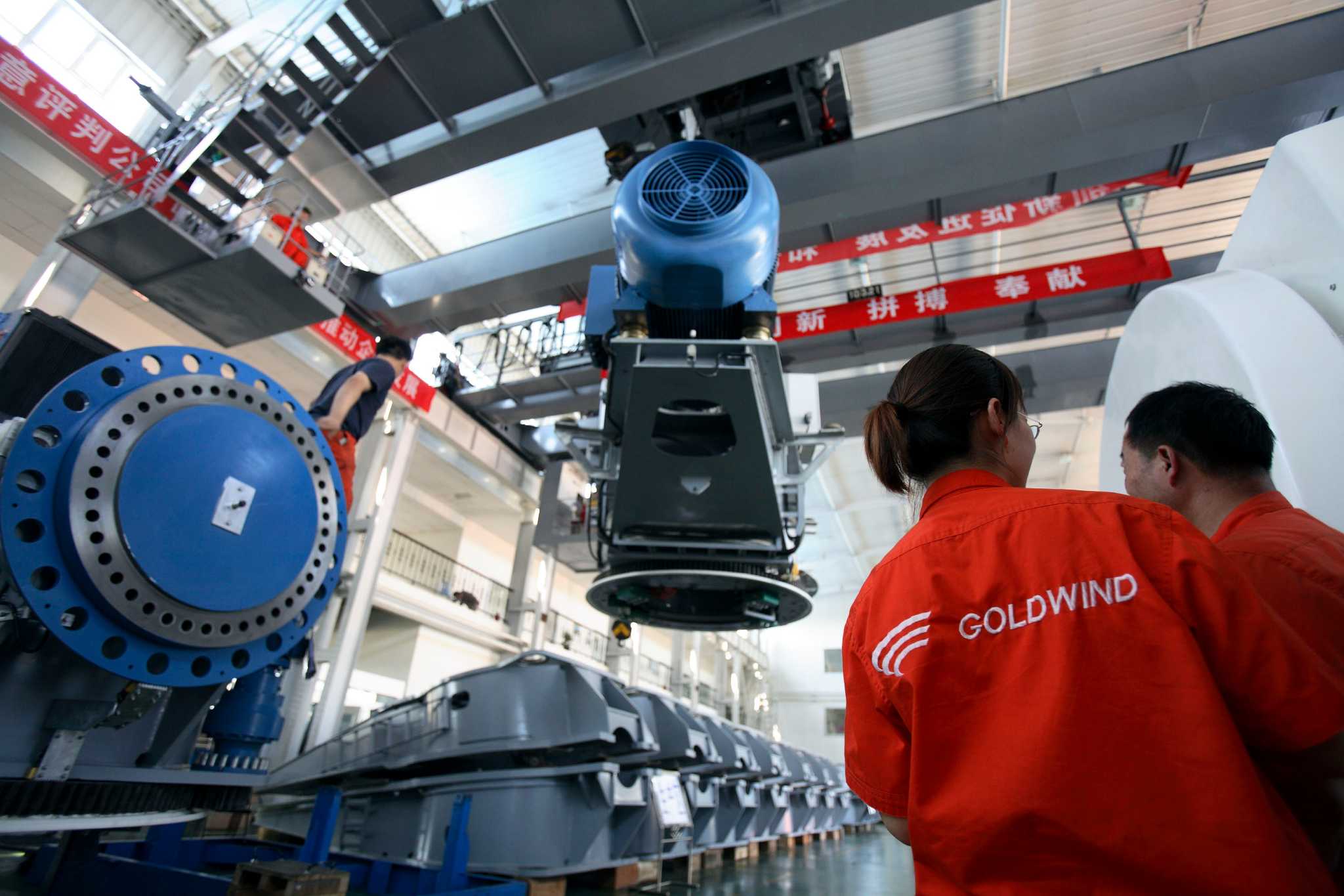 Workers assemble wind turbines at the Glodwind Science &amp; Technology Co., LTD  in Urumuqi, Xinjiang Uighur Autonomous Region,  China, on Wednesday, 01 August 2007.  Goldwind is the largest maker of power generating wind turbines in China.